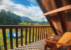 a porch of a cabin with a bench and a view at Cabana Do Lago in Joinville