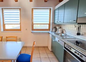 a kitchen with blue cabinets and a table and a sink at Haus 23 Natur Ferienpark - Gemütlicher Urlaubsort für entspannte Tage im Grünen und in der Nähe von den Externsteinen in Nieheim