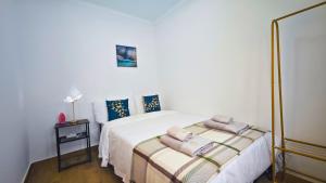 a bedroom with a bed with two towels on it at Cascais Garden House 103 in Cascais