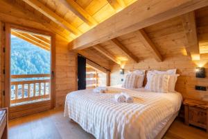 a bedroom with a bed and a large window at Chalet BO'M in Le Grand-Bornand
