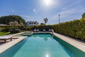 a swimming pool with two lounge chairs in a yard at Villa AMMA Pool & Jacuzzi by PikHost in Draç