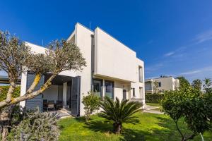 a white house with a green yard at Villa AMMA Pool & Jacuzzi by PikHost in Draç