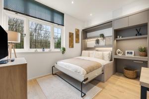 a bedroom with a large bed and two windows at Modern 2 Bed Apartment by MCF in Merstham