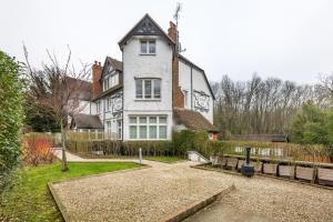 a large white house with a fence in front of it at Modern 2 Bed Apartment by MCF in Merstham