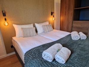 a bedroom with a large white bed with towels on it at Puur 38 in Simpelveld