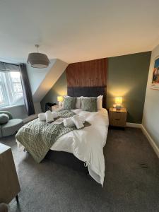 a bedroom with a large bed with white sheets and pillows at The Braeriach in Newtonmore