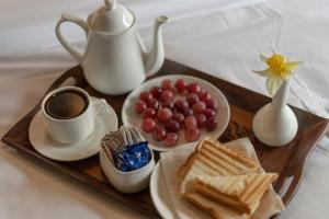 a tray with a breakfast of toast and coffee and grapes at Fimi hotel aru valley pahalgam in Ārau