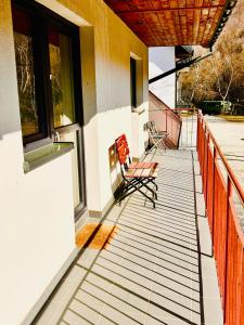 two benches sitting on the porch of a building at Pokoje Gościnne Dunajec in Zabrzeź