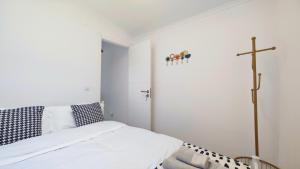 a bedroom with a bed and a cross on the wall at Cascais Garden House 105 in Cascais