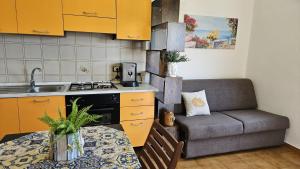 a kitchen with a table and a couch in a kitchen at Donna Pulina Holidays in Pollina