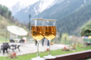 two glasses of wine sitting on a ledge at Fimi hotel aru valley pahalgam in Ārau