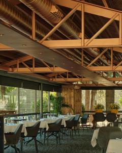 a dining room with tables and chairs and wooden ceilings at Andorra Park Hotel in Andorra la Vella