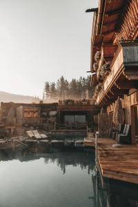 a pool of water in front of a building at Jufenalm BOHO & Wellnesshotel in Maria Alm am Steinernen Meer