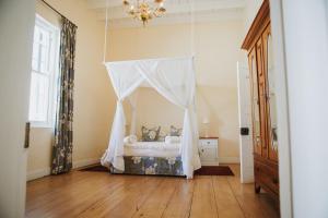 a bedroom with a bed with a canopy at Charming Historical Cottage in Graaff-Reinet