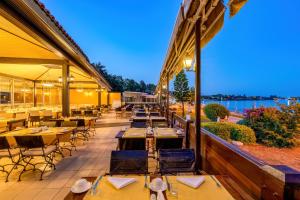 a restaurant with tables and chairs on a patio at Ozlem Garden Hotel in Side