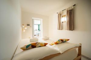 a white bedroom with a bed with a window at Terrazza vista Vesuvio e Capri con Jacuzzi privata in Naples