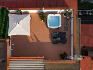 an overhead view of a house with an umbrella and a boat at Terrazza vista Vesuvio e Capri con Jacuzzi privata in Naples