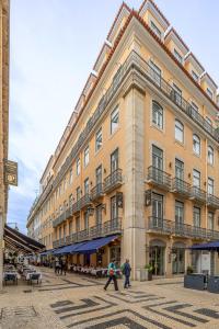 duży budynek, przed którym chodzą ludzie w obiekcie Hotel Santa Justa w Lizbonie