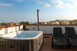 a hot tub on a balcony with two chairs at Terrazza vista Vesuvio e Capri con Jacuzzi privata in Naples