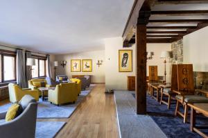 a living room with yellow chairs and tables at Parador de Fuente Dé in Fuente Dé