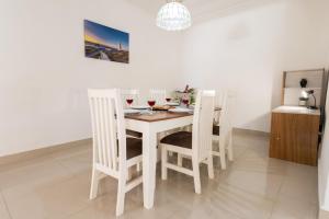 a white dining room table with four white chairs at Windsor Place by First Private Stays in Margate