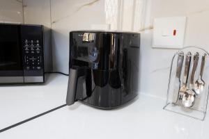 a black coffee maker on a counter next to a microwave at Windsor Place by First Private Stays in Margate
