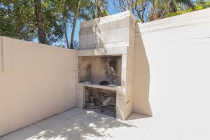 a fireplace in a white brick wall with trees in the background at Windsor Place by First Private Stays in Margate