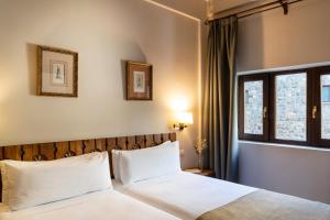 a bedroom with a bed with white pillows and a window at Parador de Fuente Dé in Fuente Dé