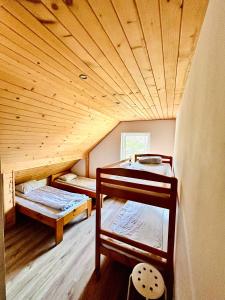 two bunk beds in a room with a wooden ceiling at Pokoje Gościnne Dunajec in Zabrzeź