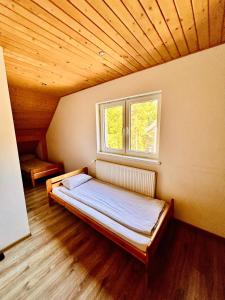 a bed in a room with a window at Pokoje Gościnne Dunajec in Zabrzeź +22 photos