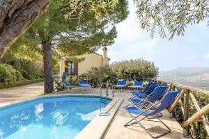 a pool with blue lounge chairs and a house at Italian Experience-Casale Dolcemare in Campofilone