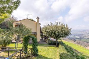 a house on a hill with a fence and trees at Italian Experience-Casale Dolcemare in Campofilone