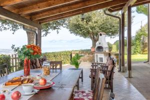 an outdoor dining area with a table and a fireplace at Italian Experience-Casale Dolcemare in Campofilone