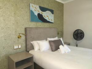 a bedroom with a bed and a clock on the wall at Eden Hotel on Florida in Durban