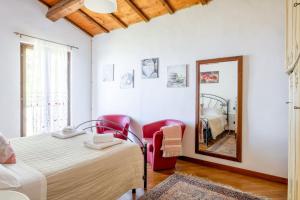 a bedroom with a bed and two red chairs and a mirror at Italian Experience-Casale Dolcemare in Campofilone +51 photos