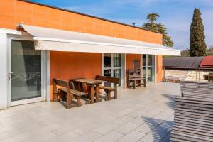 a patio with benches and an awning on a building at La Pacheca Rock Apartments in Lazise