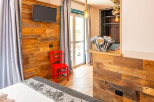 a bedroom with a wooden accent wall and a red chair at La Pacheca Rock Apartments in Lazise