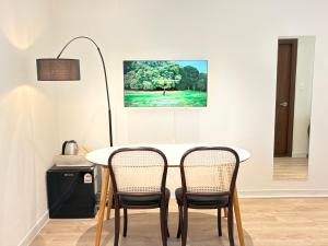 a dining room table with two chairs and a painting on the wall at SSH Ikseon peter cat Hostel in Seoul