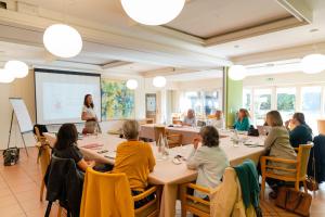 a group of people sitting around a table in a room at Le Manoir du Lys in Bagnoles de l'Orne +55 photos
