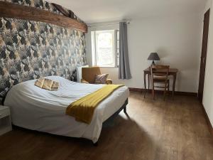 a bedroom with a bed and a chair and a window at Chez PRESSOIRS in Mesnac