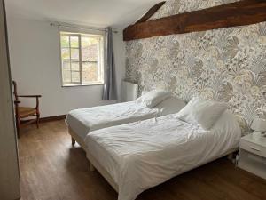 a bedroom with two beds and a window at Chez PRESSOIRS in Mesnac