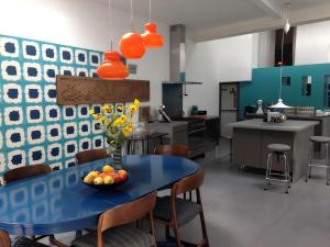 a kitchen with a blue table with a bowl of fruit on it at La Maison Bleue Trentemoult in Rezé +27 photos