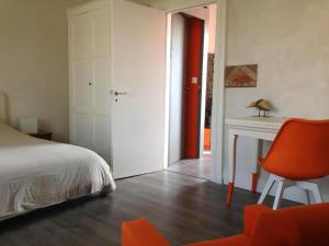 a bedroom with a bed and a desk and a chair at La Maison Bleue Trentemoult in Rezé