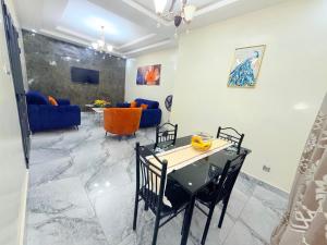 a dining room and living room with a table and chairs at House & Food in Thiès