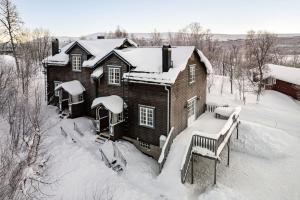 a wooden house covered in snow with a bench at Brunkulla - Tänndalen in Tänndalen