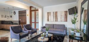 a living room with two chairs and a couch at Colonial Hotel Itatiba in Itatiba