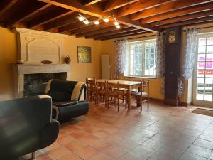 a living room with a table and chairs and a fireplace at Chez PRESSOIRS in Mesnac