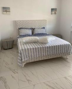 a bedroom with a bed with a striped bedspread at Villa Sassi in Nabeul