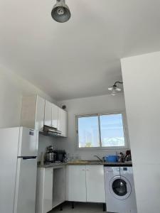 a kitchen with a white refrigerator and a window at Villa Sassi in Nabeul