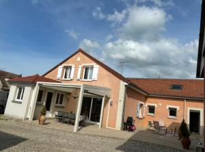 a house with tables and chairs in front of it at paddock pétillant in Auménancourt-le-Grand +20 photos